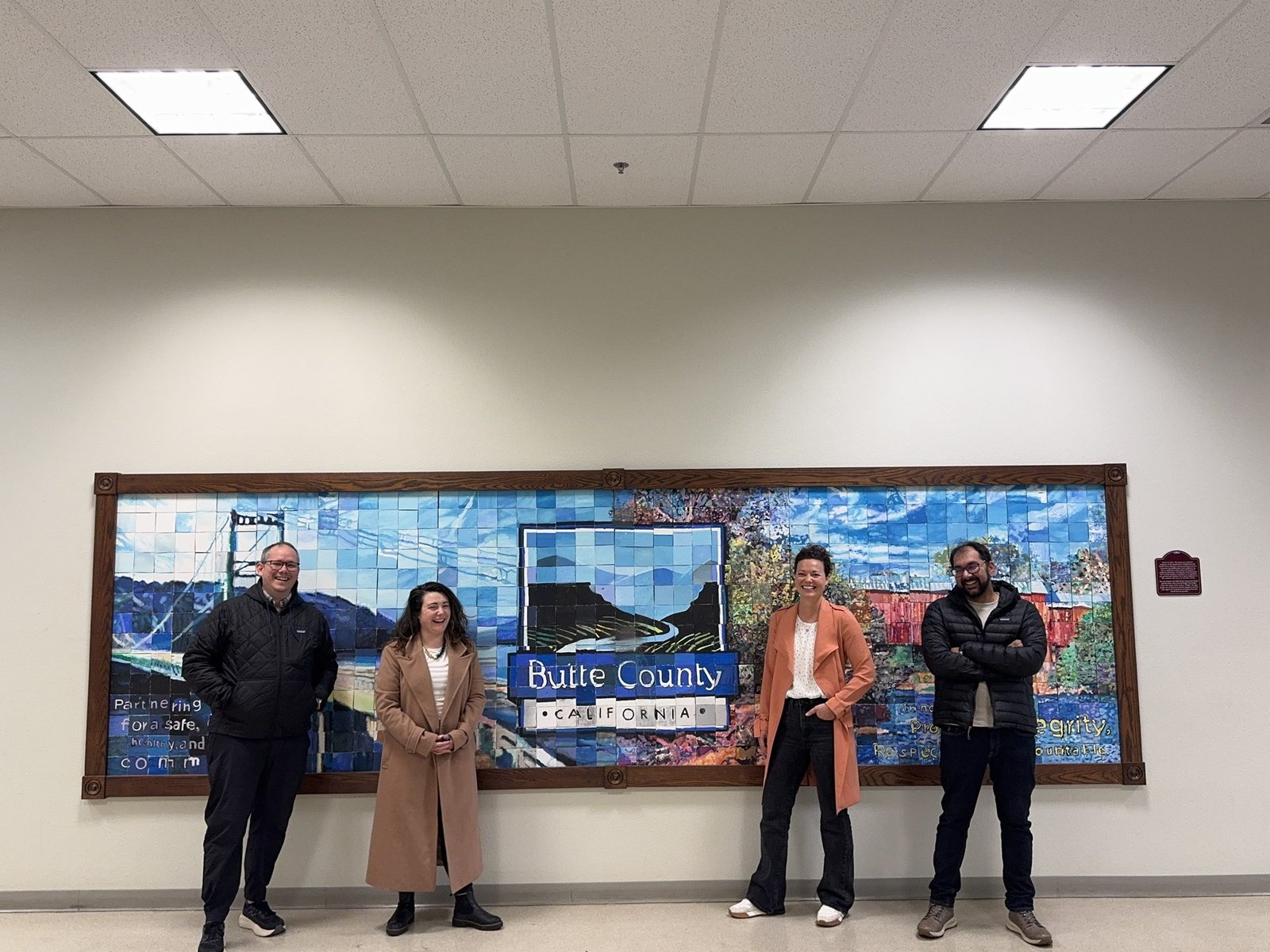 The A Spark Consulting team standing in front of the Butte County, California mural